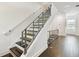 Modern staircase with dark wood steps, white risers and industrial handrail at 3100 W Paul Ave # 15, Tampa, FL 33611