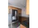 Kitchen featuring stainless steel refrigerator, granite countertops, and wood cabinets at 3123 29Th N Ave # 105, St Petersburg, FL 33713