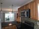 Updated kitchen with stainless steel microwave, granite countertops, and tile backsplash at 3123 29Th N Ave # 105, St Petersburg, FL 33713