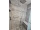 Spacious shower featuring gray tile, a built-in bench, and a rainfall shower head at 3123 29Th N Ave # 105, St Petersburg, FL 33713
