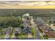 Breathtaking aerial of community featuring manicured lawns and gorgeous trees bordering a scenic lake at dusk at 31646 Baymont Loop, Wesley Chapel, FL 33543