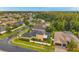 Stunning aerial view of a residential neighborhood surrounded by lush green trees and well-maintained lawns at 31646 Baymont Loop, Wesley Chapel, FL 33543
