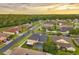 This aerial view shows the neighborhood homes, manicured lawns, and tree lined streets at sunset at 31646 Baymont Loop, Wesley Chapel, FL 33543