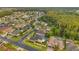 Pictureque aerial showcases the neighborhood's beautiful streets, verdant landscaping, and home with a pool at 31646 Baymont Loop, Wesley Chapel, FL 33543
