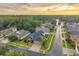 Aerial view featuring golden sunset reflecting off the water surrounded by beautiful homes in a vibrant community at 31646 Baymont Loop, Wesley Chapel, FL 33543