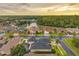 An aerial view of homes in the neighborhood near a lake, with the sunsetting over the trees at 31646 Baymont Loop, Wesley Chapel, FL 33543