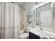 Updated bathroom with shower/tub combo, modern vanity with decorative mirror and modern patterned shower curtain at 31646 Baymont Loop, Wesley Chapel, FL 33543