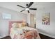 Cozy bedroom features a plush pink headboard, dark hardwood floors, and stylish ceiling fan at 31646 Baymont Loop, Wesley Chapel, FL 33543