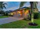 Three car garage with lights, set back from the street with well manicured lawn and landscaping at 31646 Baymont Loop, Wesley Chapel, FL 33543