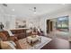 Cozy living room with access to outdoor pool, featuring leather sofa and area rug at 31646 Baymont Loop, Wesley Chapel, FL 33543