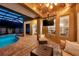 Comfortable outdoor patio with a TV and a view of the screened-in pool and spa at 31646 Baymont Loop, Wesley Chapel, FL 33543