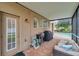 Covered patio area with comfortable seating, brick pavers and an outdoor grill at 31646 Baymont Loop, Wesley Chapel, FL 33543