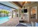 Inviting outdoor seating area with a ceiling fan, TV, and a view of the pool and screened-in patio at 31646 Baymont Loop, Wesley Chapel, FL 33543
