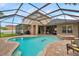 Screened-in pool and spa area featuring brick pavers, outdoor grill, and seating at 31646 Baymont Loop, Wesley Chapel, FL 33543