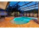 Sparkling pool and spa area enclosed in a screened lanai, surrounded by brick pavers at 31646 Baymont Loop, Wesley Chapel, FL 33543