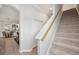 Carpeted staircase with wooden handrail adjacent to a dining room area with tile flooring at 31646 Baymont Loop, Wesley Chapel, FL 33543
