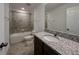Bathroom featuring granite countertops, grey tile, and tub with tile surround at 38120 Shale Stone Ct, Zephyrhills, FL 33540