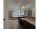 Bathroom with dual vanities, large mirror, glass shower, and separate tub at 38120 Shale Stone Ct, Zephyrhills, FL 33540
