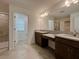 Bathroom with double vanity, granite countertop, and tile flooring, offering a modern and functional space at 38120 Shale Stone Ct, Zephyrhills, FL 33540