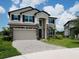 Charming two-story home featuring stone accents, a two-car garage, and a well-manicured lawn at 38120 Shale Stone Ct, Zephyrhills, FL 33540