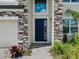 Close-up of the front door highlighting the stone facade and tiled walkway at 38120 Shale Stone Ct, Zephyrhills, FL 33540
