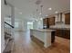 Open-concept kitchen with a center island, stainless steel appliances, and wood-style flooring at 38120 Shale Stone Ct, Zephyrhills, FL 33540