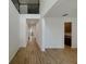 Bright living room with wood-look tile flooring and hallway leading to the staircase at 38120 Shale Stone Ct, Zephyrhills, FL 33540