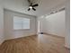 Bright living room featuring wood-look tile floors and a modern ceiling fan at 38120 Shale Stone Ct, Zephyrhills, FL 33540