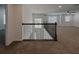 Open loft area featuring neutral carpet, ceiling fan, and decorative iron railing overlooking the entry at 38120 Shale Stone Ct, Zephyrhills, FL 33540