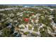 Aerial view of a charming neighborhood with mature trees and well-manicured lawns. The home is marked with an arrow at 399 Walnut Ct, Palm Harbor, FL 34683