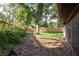 Side view of the backyard featuring mature landscaping and a wood fence at 399 Walnut Ct, Palm Harbor, FL 34683