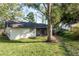 Spacious backyard featuring a lush green lawn and mature trees offering plenty of shade at 399 Walnut Ct, Palm Harbor, FL 34683