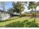Beautiful backyard showcasing a well-maintained lawn, lovely fence, and mature trees at 399 Walnut Ct, Palm Harbor, FL 34683