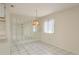 Bright dining room with tiled flooring, neutral paint, modern mirror accents, and a hanging pendant light at 399 Walnut Ct, Palm Harbor, FL 34683
