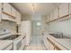 Well-lit kitchen featuring white appliances and cabinets, and tiled flooring at 399 Walnut Ct, Palm Harbor, FL 34683