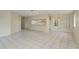 Bright and spacious living room with tiled flooring, open layout, neutral paint and access to the kitchen at 399 Walnut Ct, Palm Harbor, FL 34683