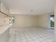 Bright living room with tiled flooring, neutral paint, bar seating, and sliding glass doors to the exterior at 399 Walnut Ct, Palm Harbor, FL 34683