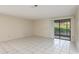 Bright living room featuring tiled flooring, neutral paint, and sliding glass doors to the exterior at 399 Walnut Ct, Palm Harbor, FL 34683
