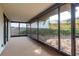 View of the carpeted screened-in porch with view of the backyard at 399 Walnut Ct, Palm Harbor, FL 34683