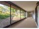View of a carpeted screened-in porch with access to backyard at 399 Walnut Ct, Palm Harbor, FL 34683