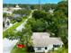 An aerial view of a white home with a shingled roof nestled among lush green trees on a sunny day at 4300 16Th N Ave, St Petersburg, FL 33713