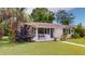 Charming home with a blue door, matching shutters, and a bench surrounded by lush greenery at 4300 16Th N Ave, St Petersburg, FL 33713