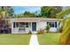 Charming home with well-maintained lawn, a blue door, matching shutters, and a cozy bench on the porch at 4300 16Th N Ave, St Petersburg, FL 33713