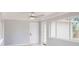 Spacious living area with a ceiling fan, large windows, and an adjacent door at 4300 16Th N Ave, St Petersburg, FL 33713