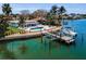Aerial view of waterfront property with dock, boat lift, pool, and lush landscaping at 4381 Poinsettia Dr, St Pete Beach, FL 33706