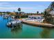 Waterfront property with private dock, boat lift, pool, patio, and manicured lawn at 4381 Poinsettia Dr, St Pete Beach, FL 33706