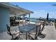 A waterfront patio with a dining set, lounge chairs, a pool, and beautiful water views at 4381 Poinsettia Dr, St Pete Beach, FL 33706