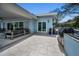 A covered patio with a lounge area and seamless access to the outdoor kitchen at 4381 Poinsettia Dr, St Pete Beach, FL 33706