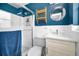 Cozy bathroom with white tile, blue accents, and a glass-enclosed shower at 4381 Poinsettia Dr, St Pete Beach, FL 33706