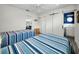 Bright bedroom with two beds, wood floors, and modern sliding door to bathroom at 4381 Poinsettia Dr, St Pete Beach, FL 33706